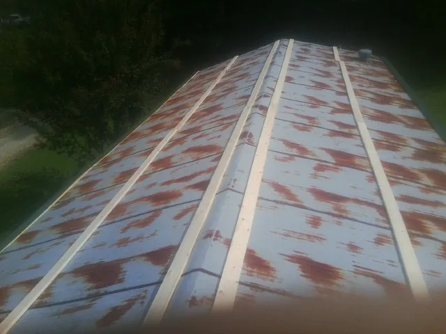 Rusted metal roof panels with new wood purlins before replacement — Storm Damage Roof Repair in Freeport by Roofing Brothers